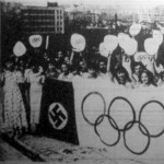 Japán fiatalok zászlókkal ünneplik egy toronyház tetején, hogy Tokiónak ítélték az 1940-es olimpiát