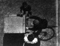 Egy ház erkélyéről lefényképezett biczikliző szállitó szolga. Csak a kalapját, hátá és a két kinyujtott katját látjuk