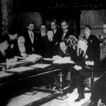 Az asztalfőn Mussolini jegyzi alá nevét, balra tőle Pasics jugoszláv miniszterelnök, Mussolinitől jobbra Nincsics jugoszláv külügyminiszter látható
