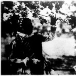 Virágzik az almafa. Kalocsavidéki (Homokmégy) lányok festői népviseletben egy virágzó almafa alatt.
