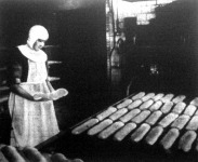 A péknővér a dagasztógépből kirakja a szakajtott kenyeret