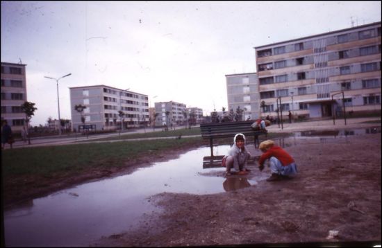 Pocsolya mellett játszadozó gyermekek egy épülő lakótelepen